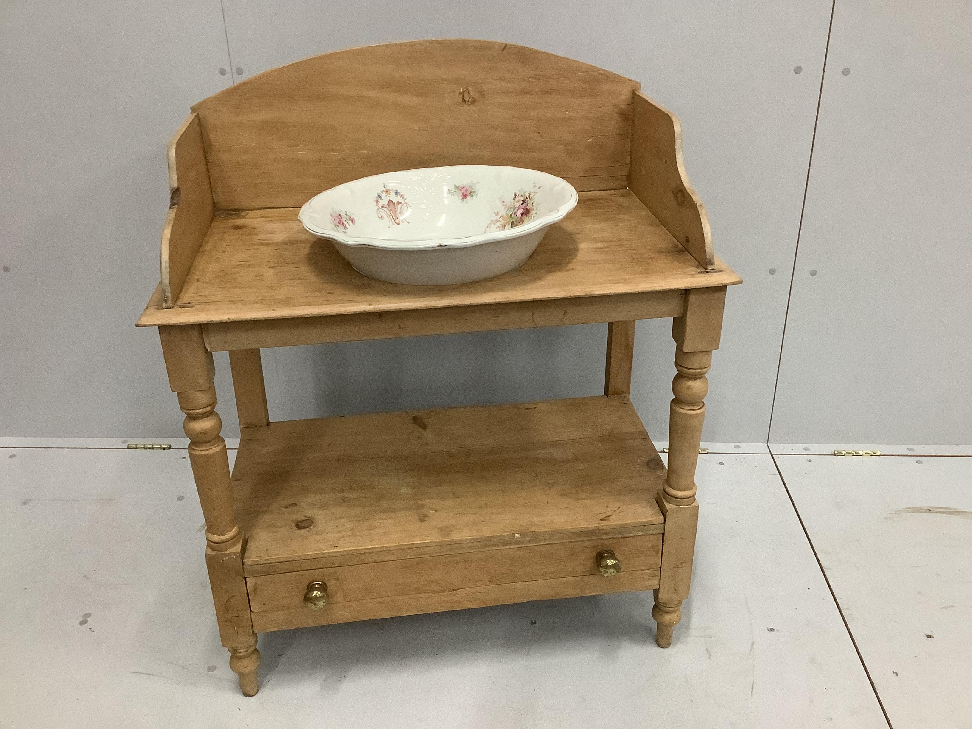 An Edwardian beech washstand with base drawer and associated ceramic basin, width 84cm